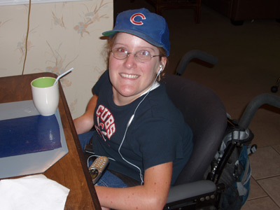 teenage girl with Chicago Cubs hat on sitting at a desk