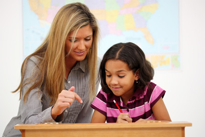 teacher helping young female student